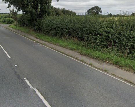 Google Street View of the footway at Wolvey, Warwickshire: a narrow footway beside a rural road with a hedge